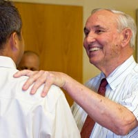 Bill Badger shakes hands with another man at his last lecture.