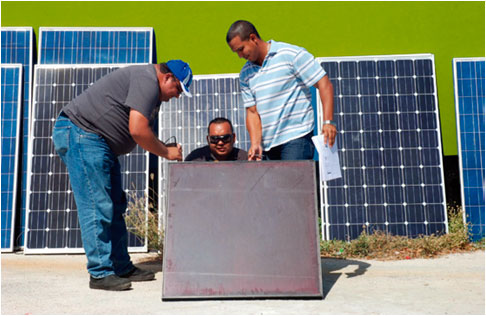 An instructor explains details of a solar panel to students.