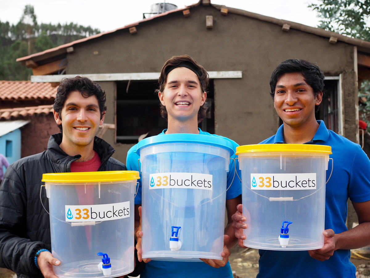 Mark Huerta, Vid Micevic and Swaroon Sridhar of 33 Buckets pose with their water containers in Peru