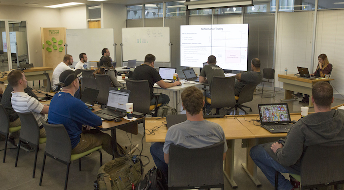 A photo of students sitting in a classroom with a caption of "Attendees of the microgrid bootcamp learn the ins and outs of microgrid setup, operation and optimization during one of the weeklong program's classes on the Polytechnic campus. Photographer: Pete Zrioka/ASU."