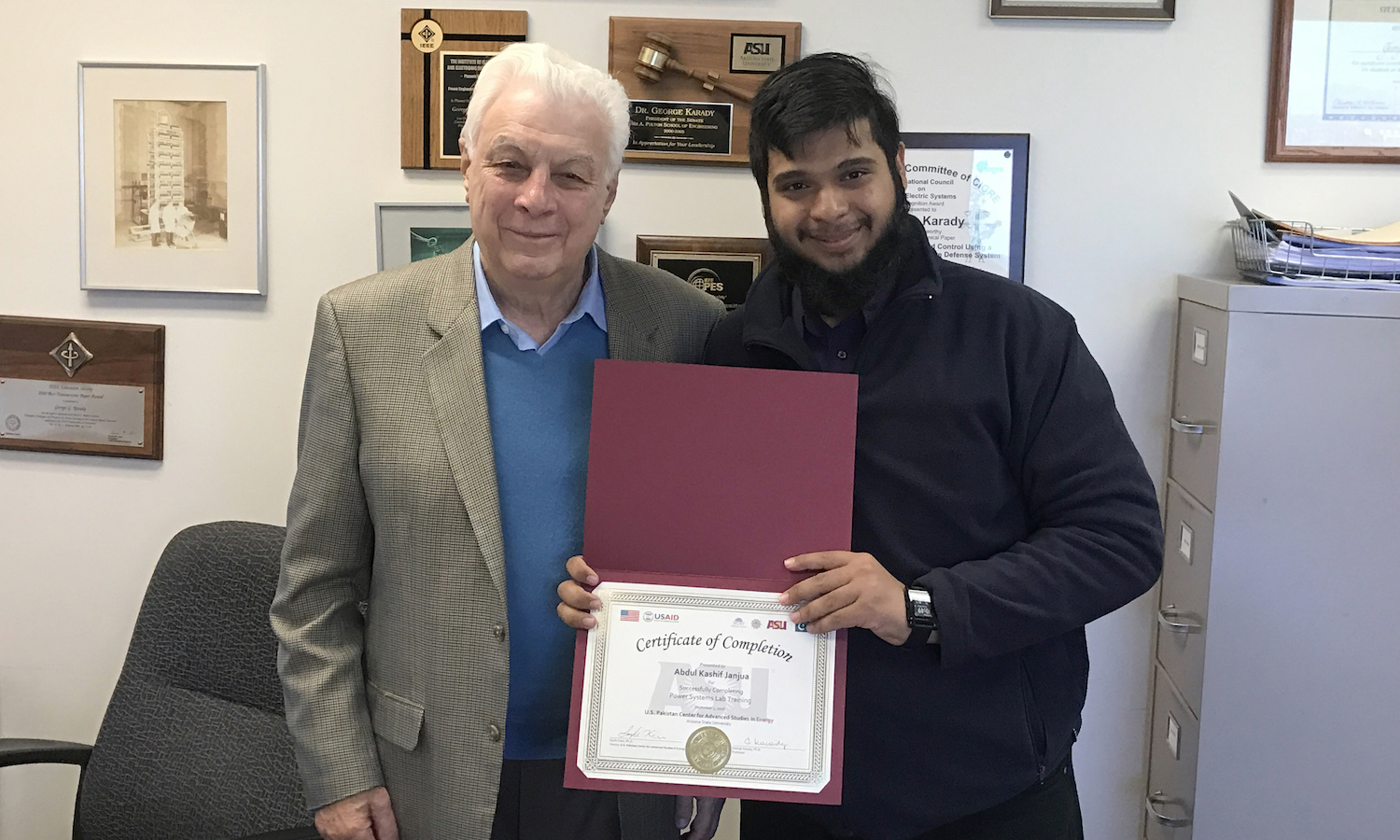 Photo of two men standing next to one another with one of them holding a certificate. Caption: Abdul Kashif Janjua, exchange scholar from the U.S.-Pakistan Centers for Advanced Energy, known as USPCAS-Ewith his certificate of completion from the Power System’s Lab in fall 2016. Photo courtesy of Abdul Kashif Janjua