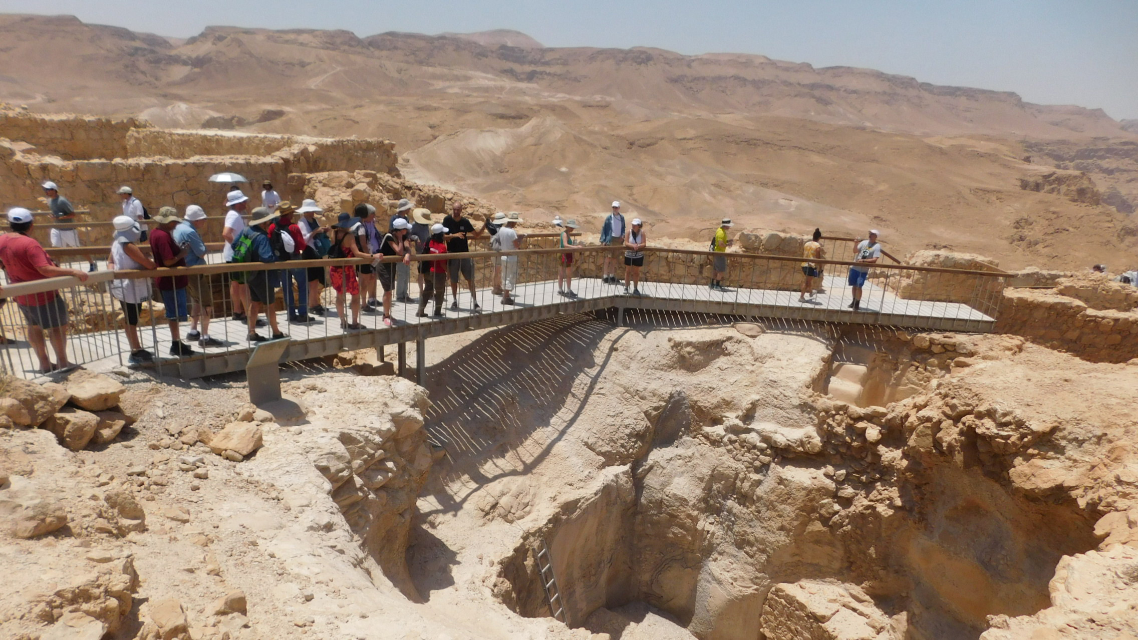 Photo of group of people on a walkway at Masada. Caption: The Faculty Fellowship in Israel Program takes participants to major historic and cultural sites such as Masada, where there are remains of an ancient fortress overlooking the Dead Sea in the Judean Desert. Dating to about 30 B.C., the site includes the ruins of King Herod's palace. Recreations of historical scenes and archaeological exhibits are on display in The Masada Museum. Photographer: René Reinhard/Jewish National Fund.