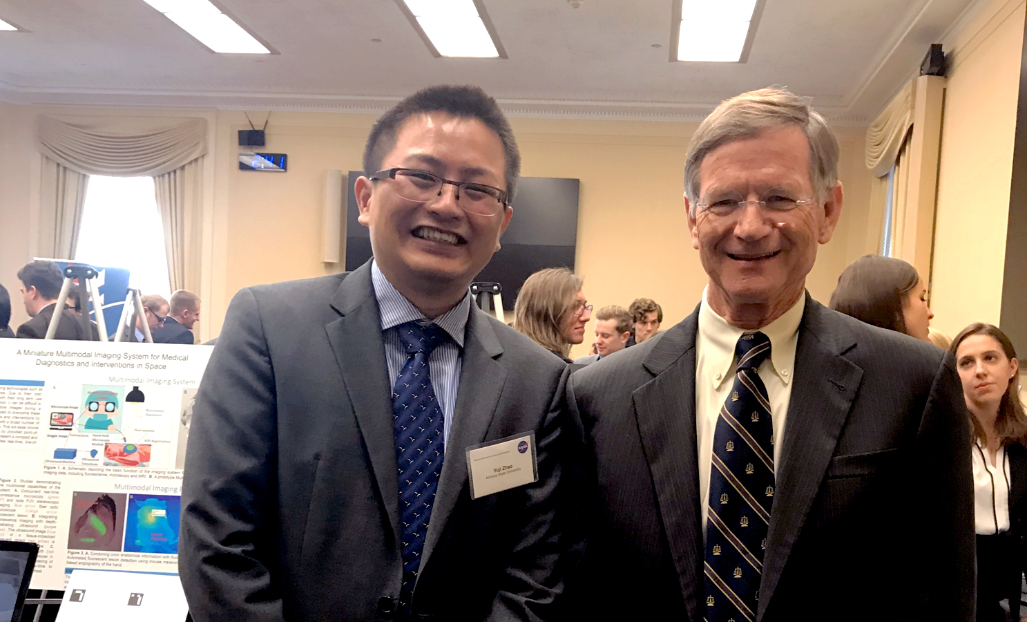 Photo of two men standing next to each other. Caption: Yuji Zhao (left) poses with U.S. Representative Lamar Smith, chairman of the Committee on Science, Space, and Technology. Zhao was one of a select few invited to meet with members of Congress to talk about advances in technology for space applications during the November 29 NASA Tech Day event. Photo courtesy of Yuji Zhao