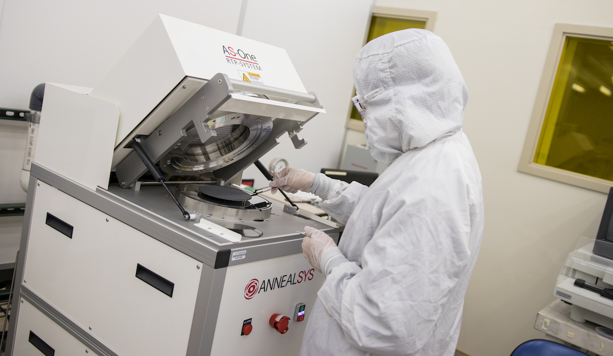 Photo of a student working in a clean room. Caption: A student is pictured at NanoFab unloading a wafer — a thin slice of semiconductor materials used to make electrical circuits — from the vacuum of a rapid thermal processing machine. It’s one of the facility’s advanced research tools that enable both established companies and startup ventures to perform state-of-the-art fabrication, prototyping and testing for new products. Photographer: Marco-Alexis Chaira/ASU