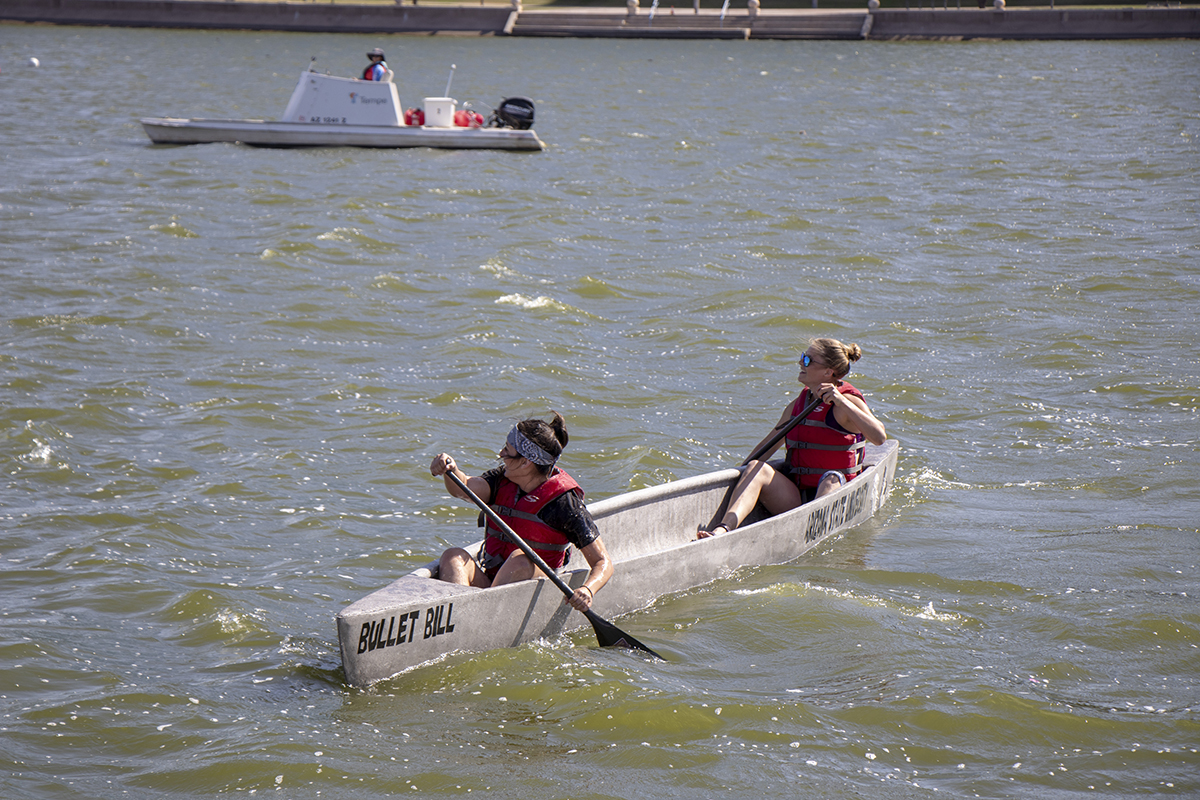 Photo of two people in a canoe. Caption: Tempe Town Lake near the Arizona State University campus was the site of the concrete canoe contest, a signature event in the American Society of Civil Engineers annual student competition. Pictured are two ASU students steering their team’s canoe, named “Bullet Bill.” Photographer: Marco-Alexis Chaira/ASU