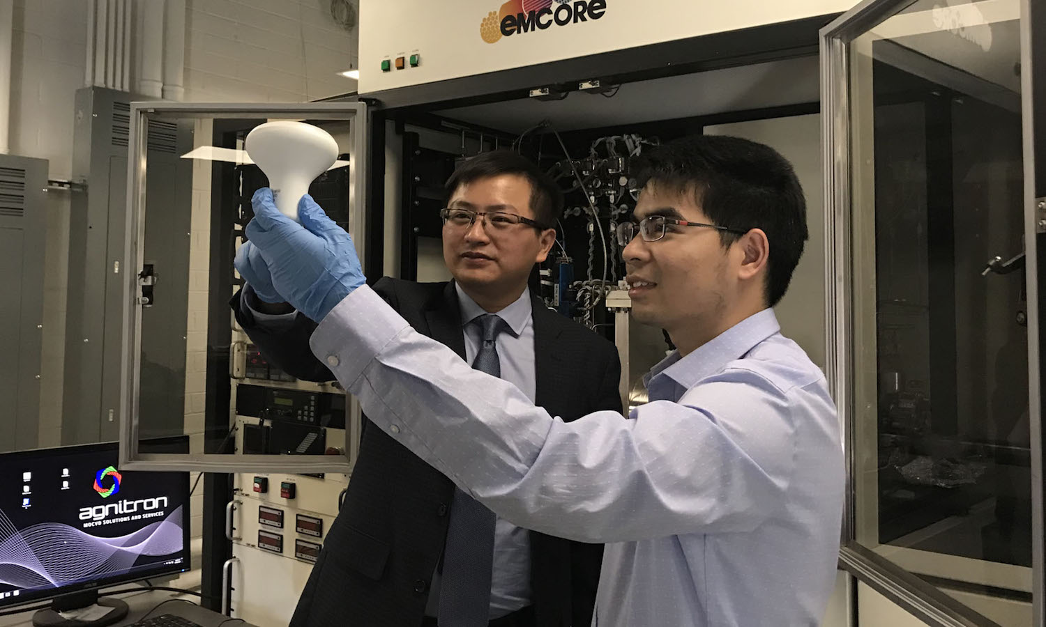 Photo of two men in a lab with one holding a lightbulb. Caption: Yuji Zhao (left), an electrical engineering professor in Arizona State University’s Ira A. Fulton Schools of Engineering, and Houqiang Fu (right), a doctoral student in Zhao’s research group, hold an LED light bulb. Zhao and Fu are authors on a paper recently published in a leading photonics journal highlighting the theoretical limits and future directions for light-emitting diode technology. Photo courtesy of Yuji Zhao