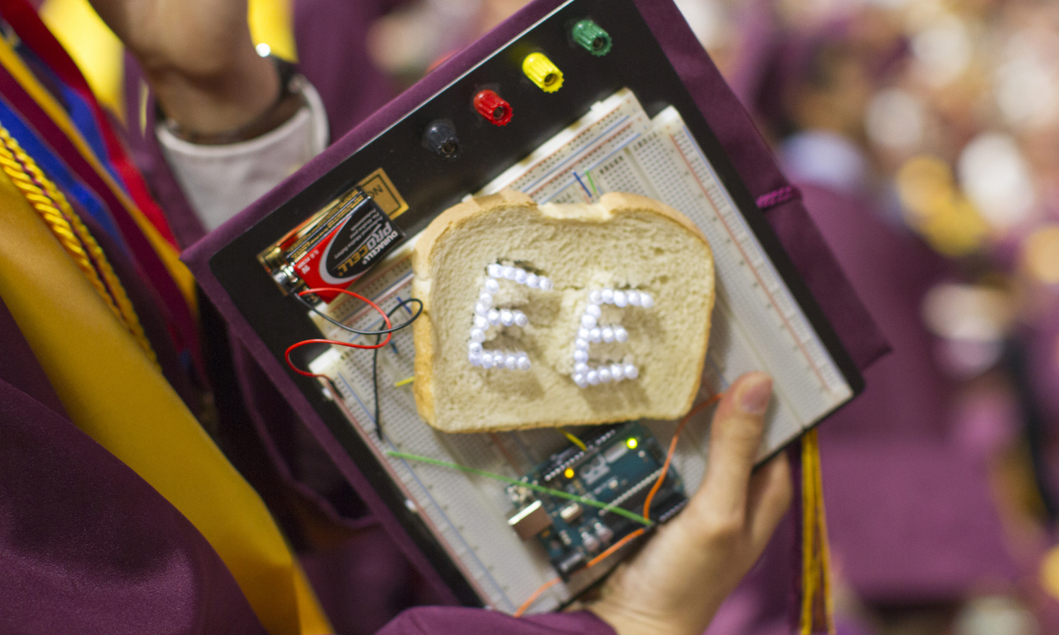 Photo shows an electrical engineering graduate's mortarboard decorated as a breadboard.