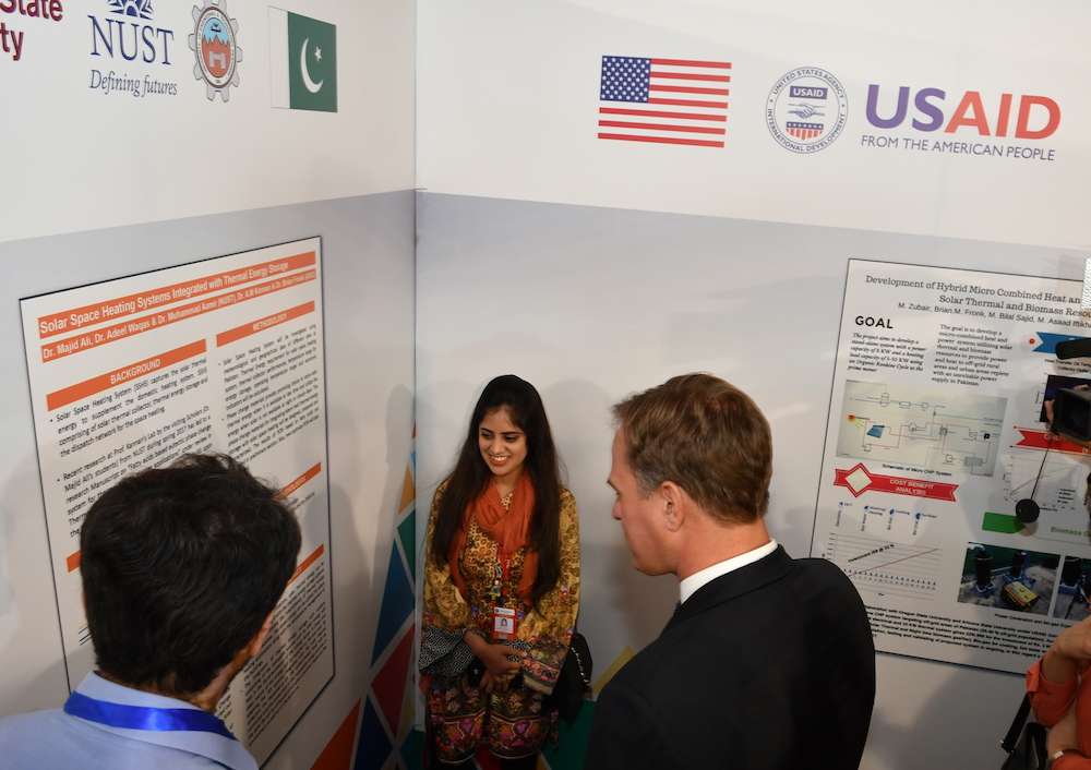 three people looking at a research poster