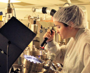 girl in lab coat looking at items with a flashlight