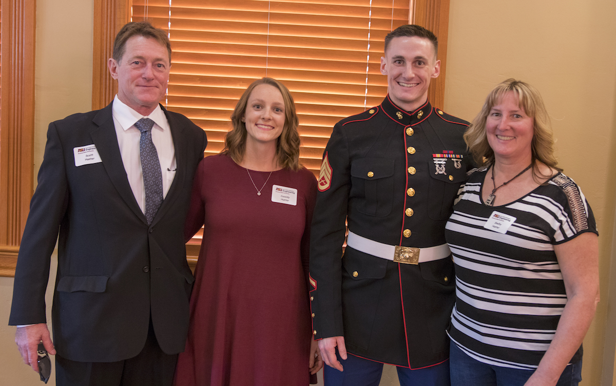Family of four standing next to each other