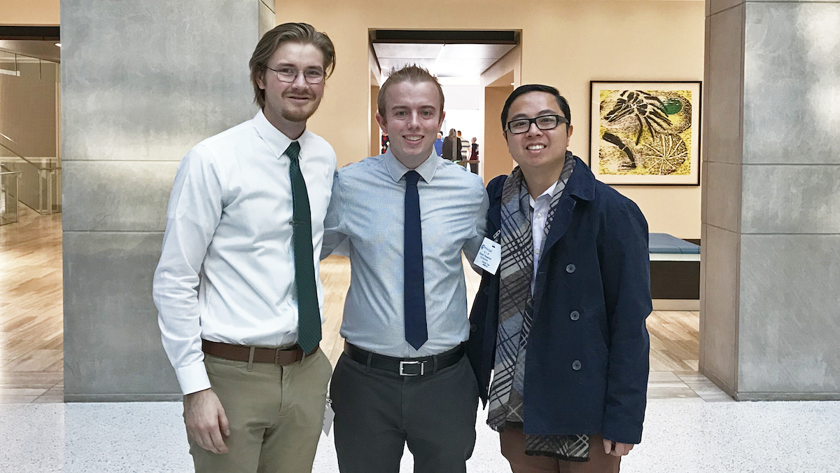 Three students standing in a row