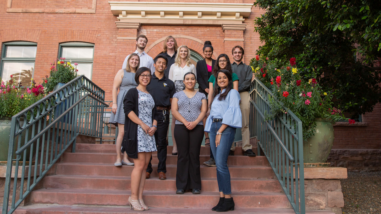 Eleven students pose on the steps of the University Club building on Arizona State University's Tempe campus.