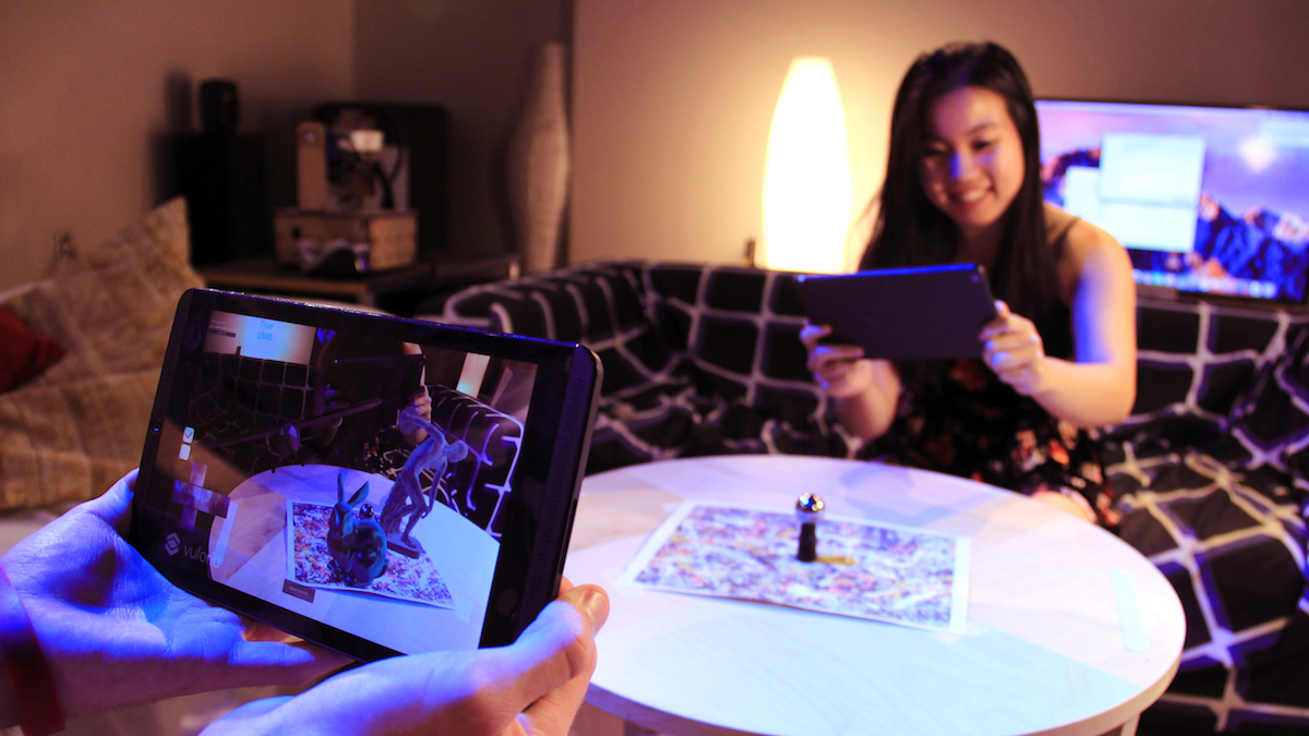 a man holding a tablet with augmented reality images showing up on the screen