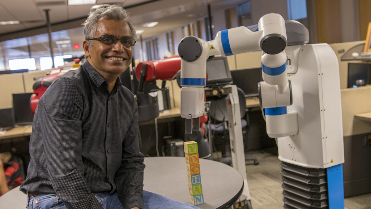 man next to a robotic arm