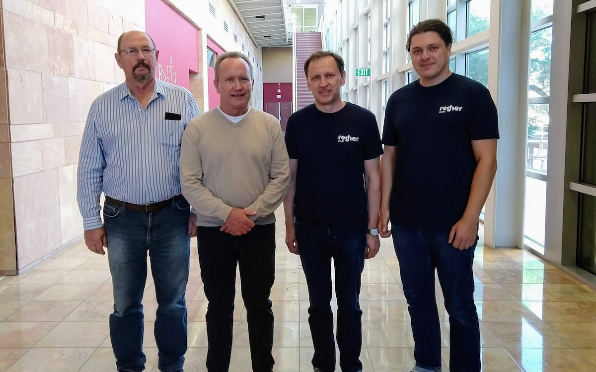Four men standing in a hallway