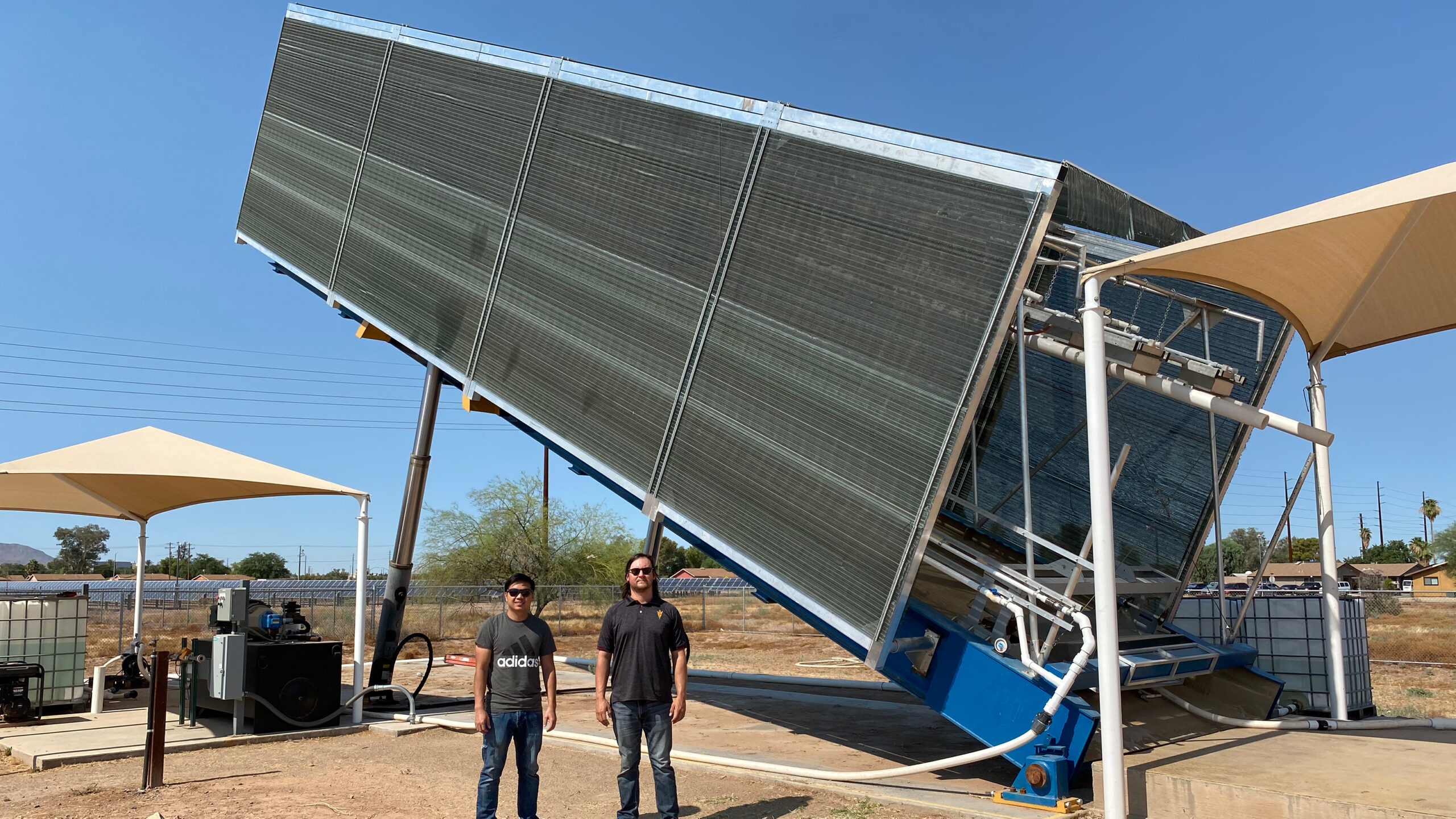 two students standing in front of a large rectangular obect that is tilted