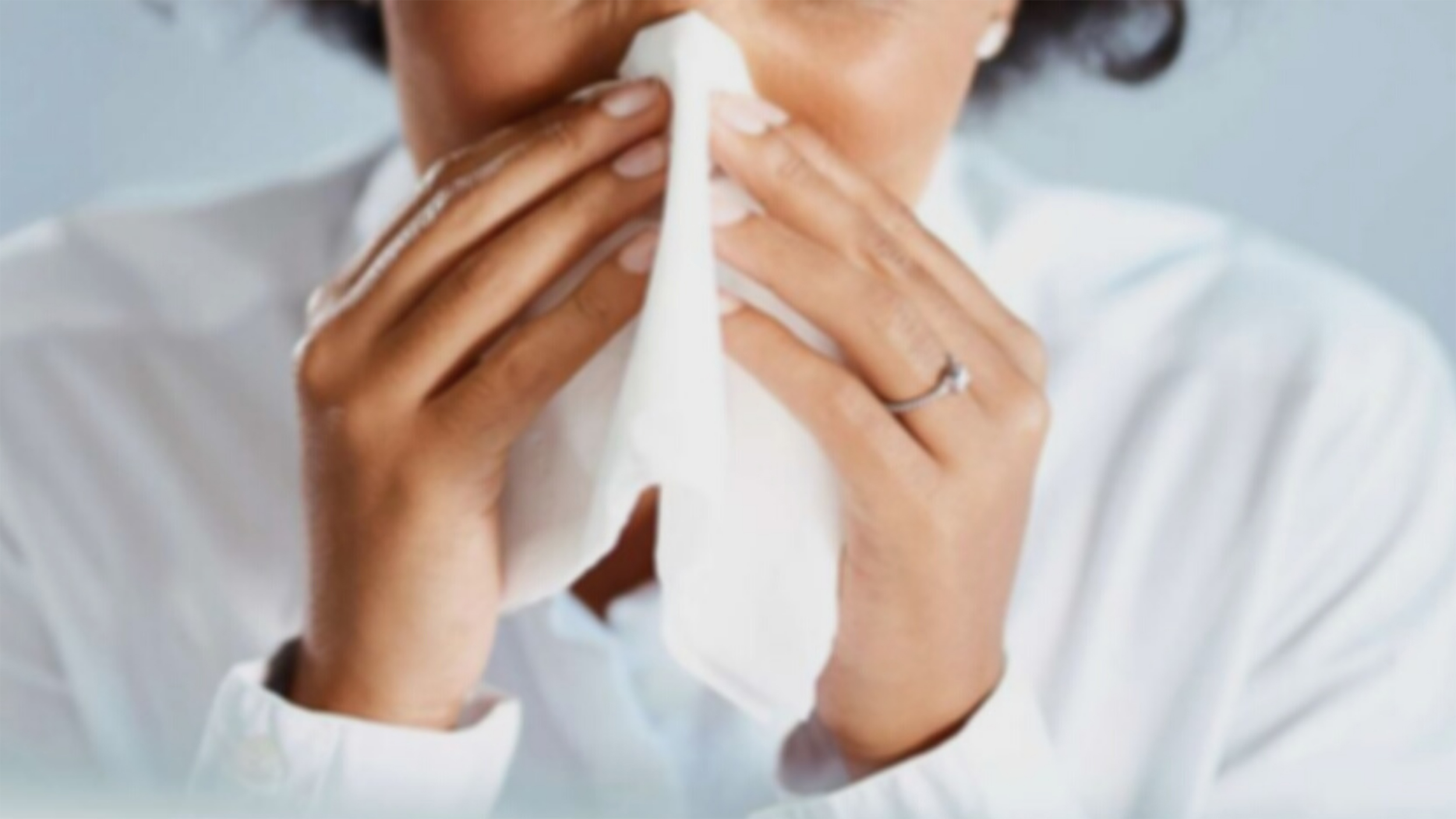 photo of a person holding a tissue to their nose