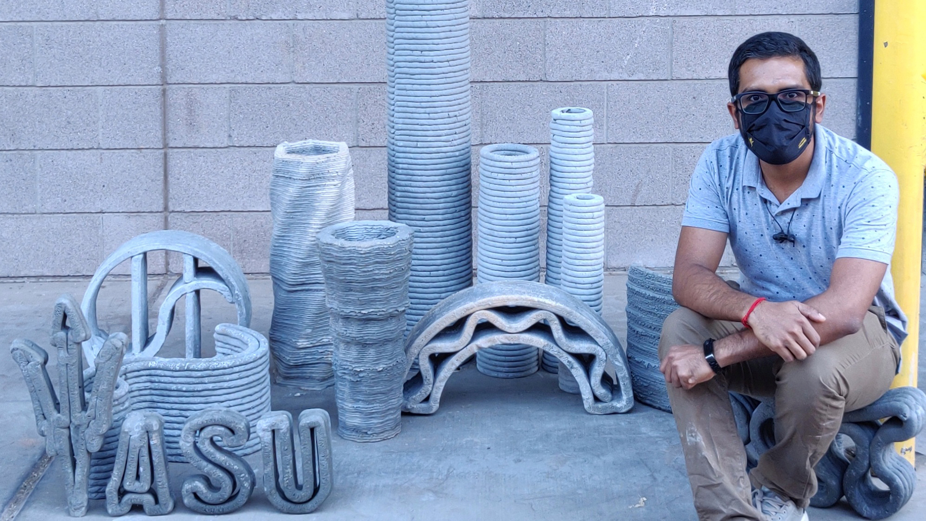 man seated near creatios made of printed concrete
