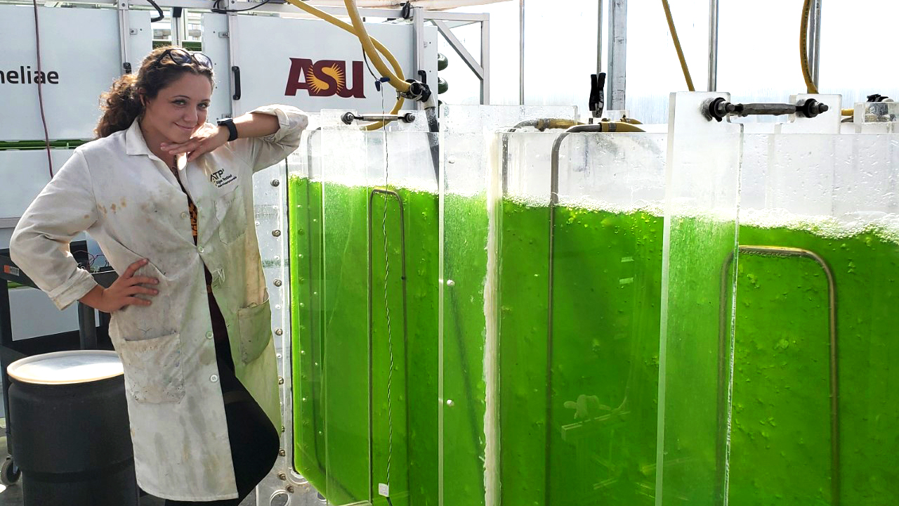 woman standing next to algae containers