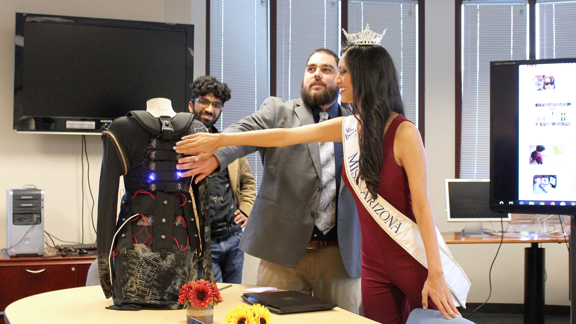 Bryan Duarte showing Miss Arizona 2018, Isabel Ticlo a demonstration of haptics technologies.