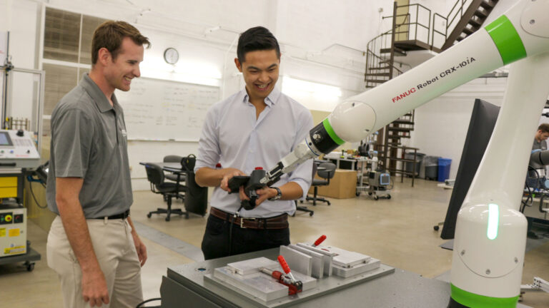 Ammon Hall and student operating a robot