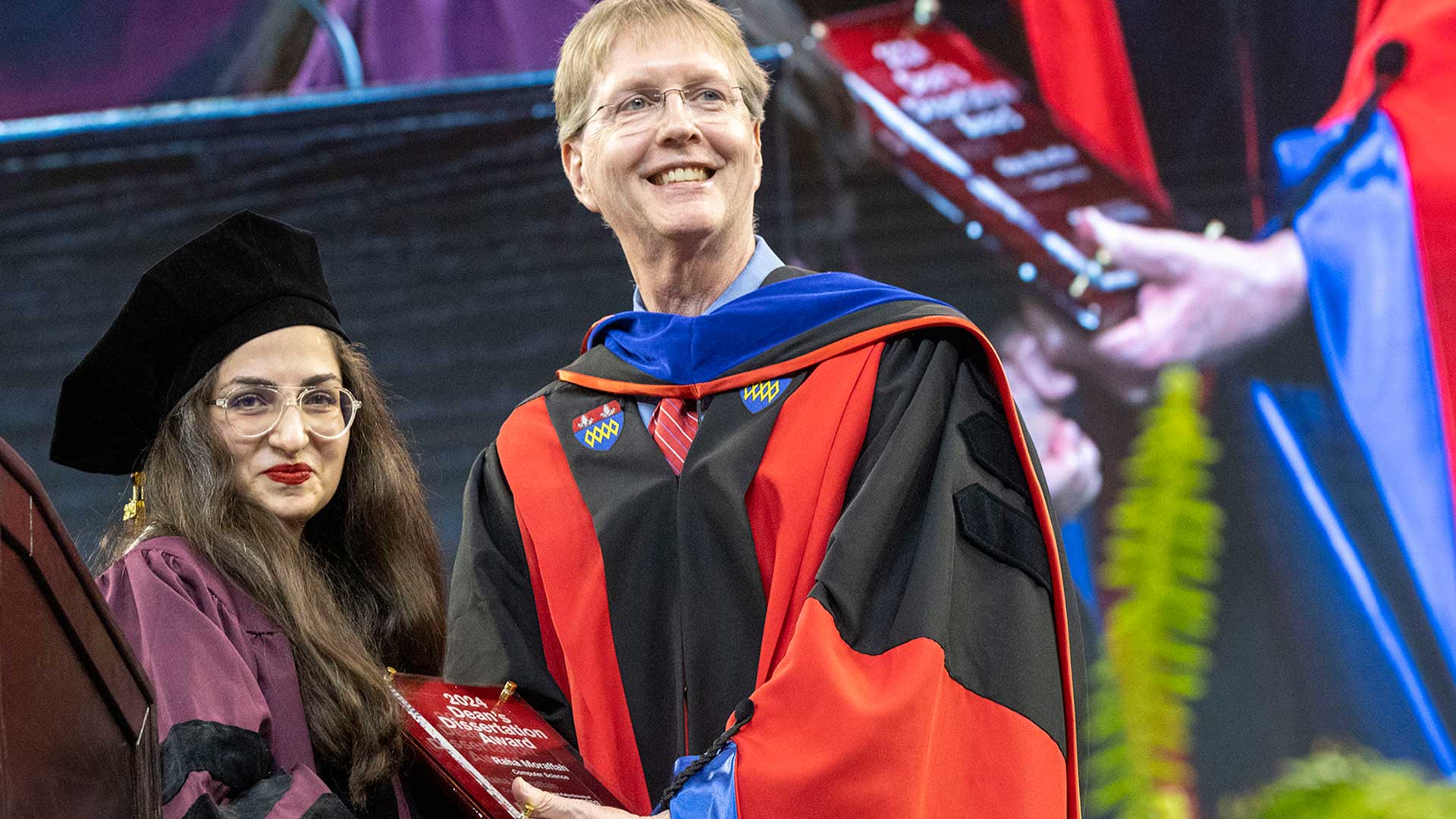 Raha Moraffa shakes hands with Kyle Squires.