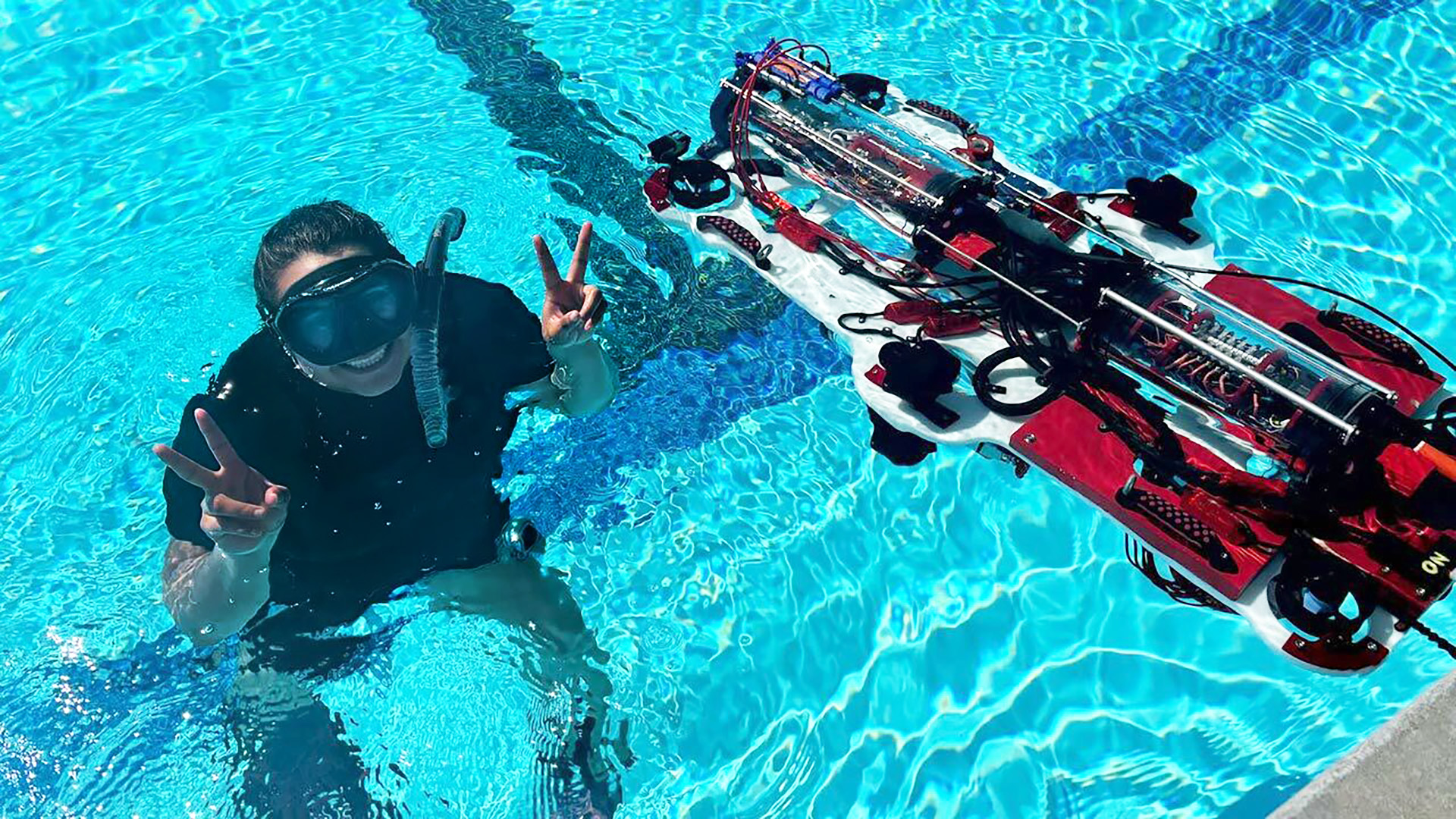 Litzi Matancillas in a pool with a robotic submarine