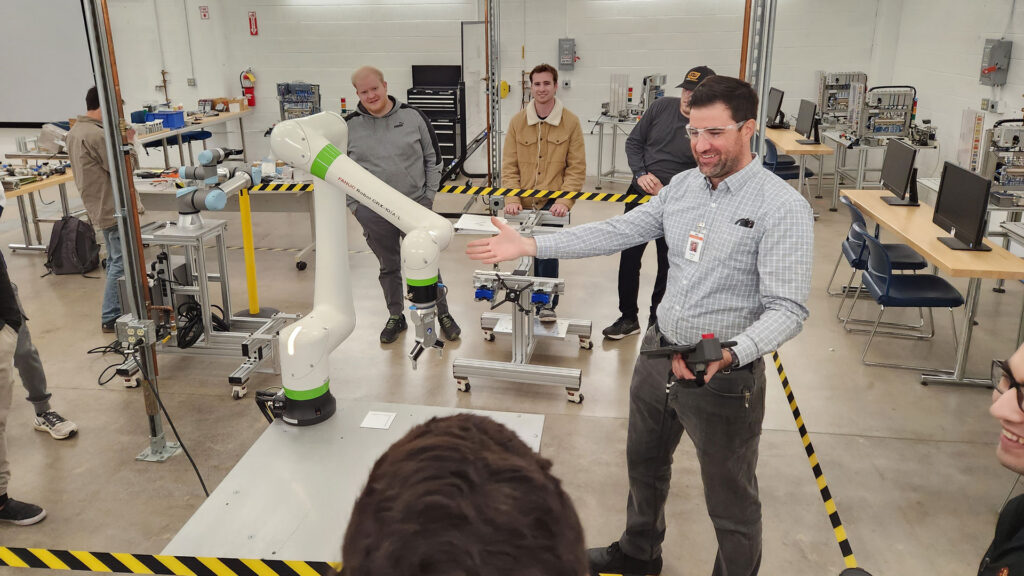 Jason Floor demonstrating equipment in the Industrial Automation and Robotic Systems Laboratory. 