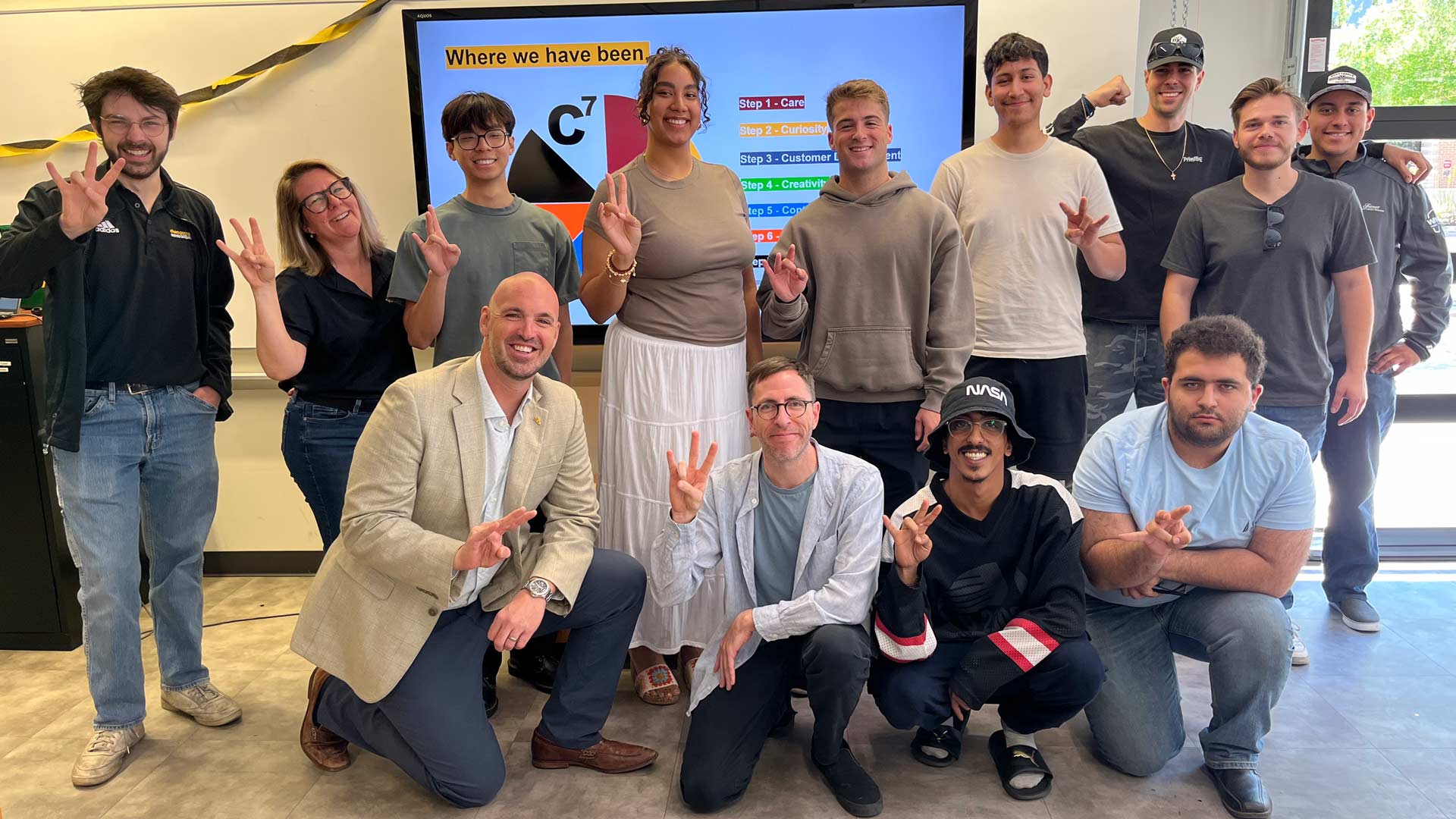 Students posing together and smiling and making pitchforks.