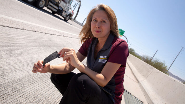 Elham-Fini holding a piece of asphalt.