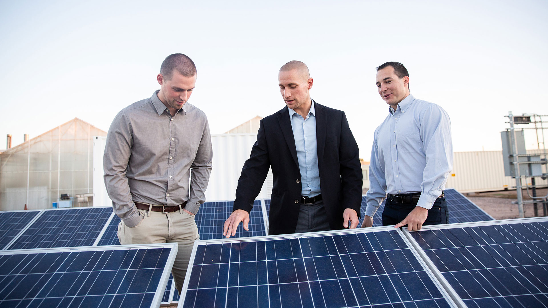 Nathan Johnson inspects solar panels with colleagues.