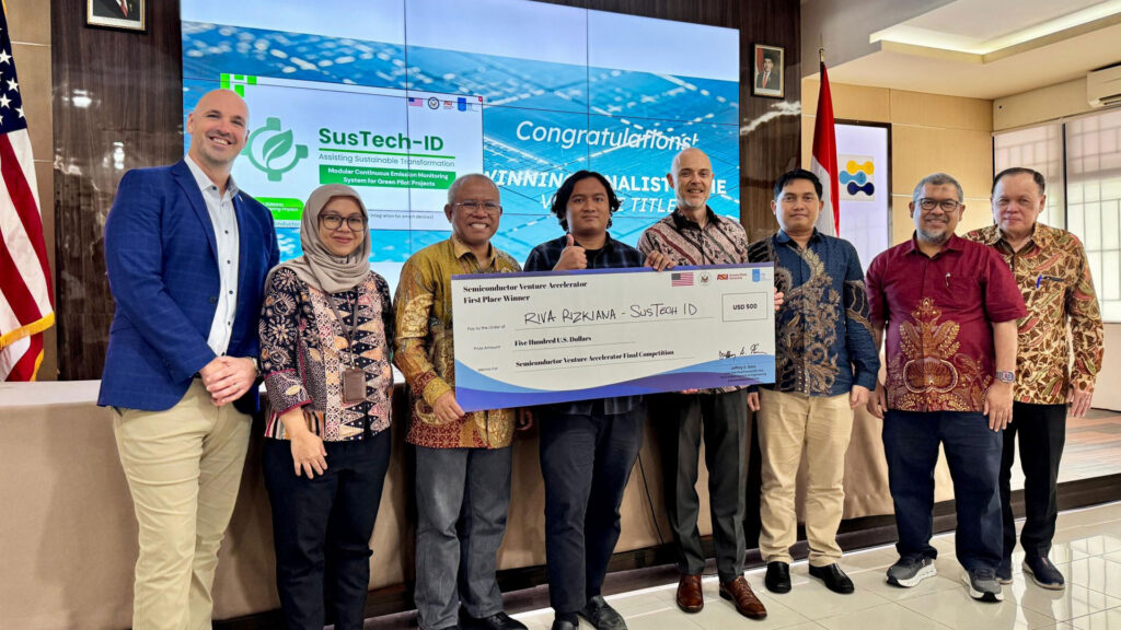 Riva Rizkiana holding a check after winning semiconductor pitch competition