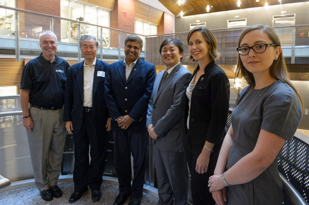 Researchers pose in the entryway of a building.