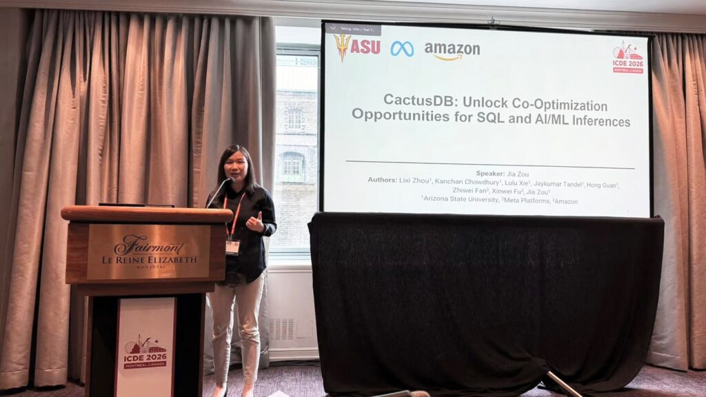 Jia Zou stands near a podium and speaks during a conference.